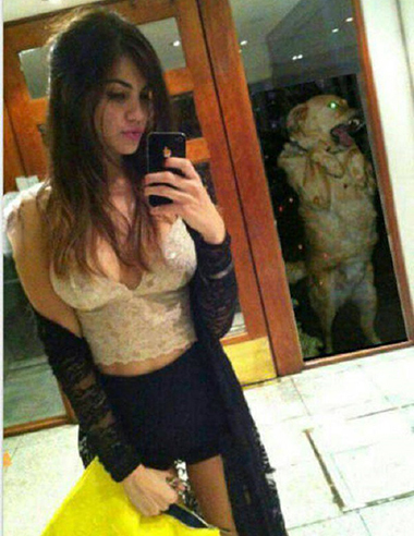 自撮りする女性の後ろにいる変な犬
